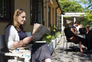 Woman reading newspaper in the sun