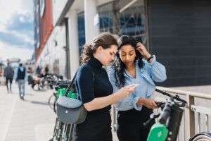 Women on scooters with mobile phone