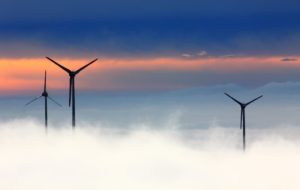 Wind mills in the clouds with sunset in background